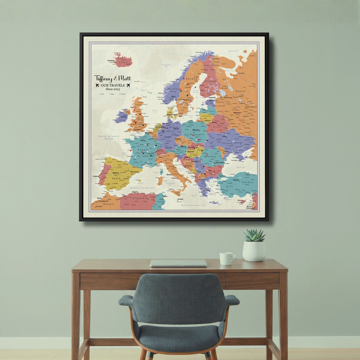 Personalized tan ocean Europe push pin travel map on canvas in black frame above desk