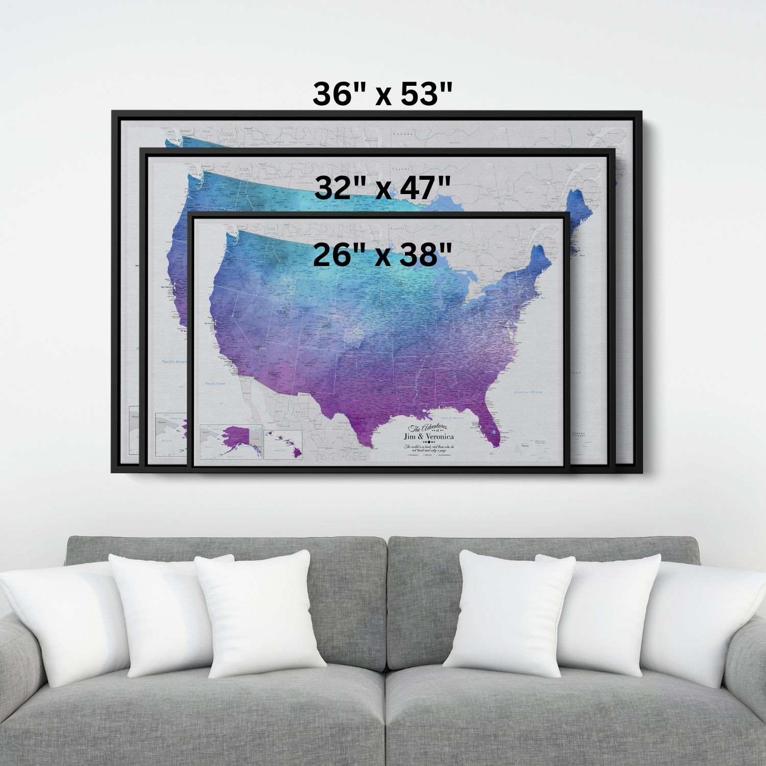 Three size options of framed vibrant violet watercolor USA travel map canvas displayed above gray sofa