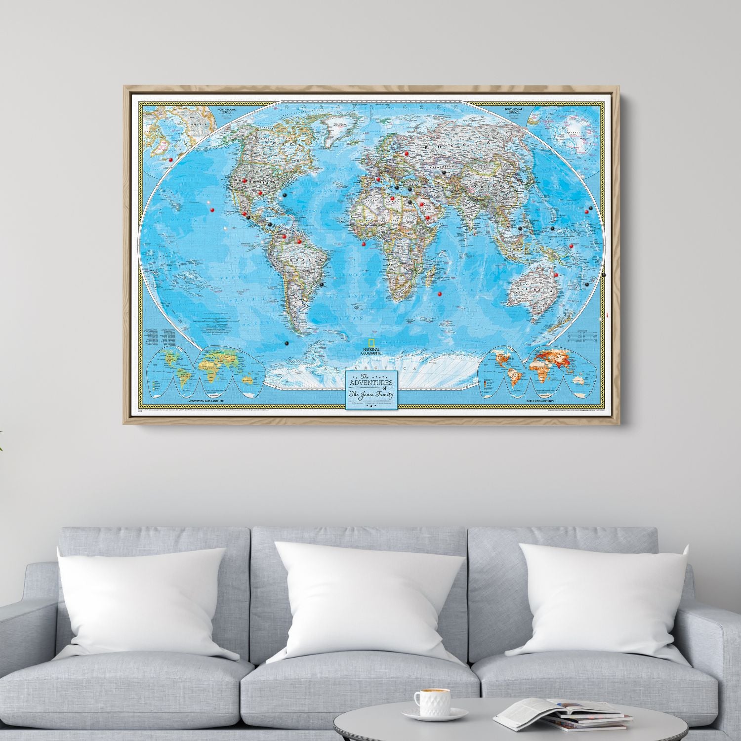 Framed Classic World Travel Map canvas with red and black pins hung above gray living room sofa