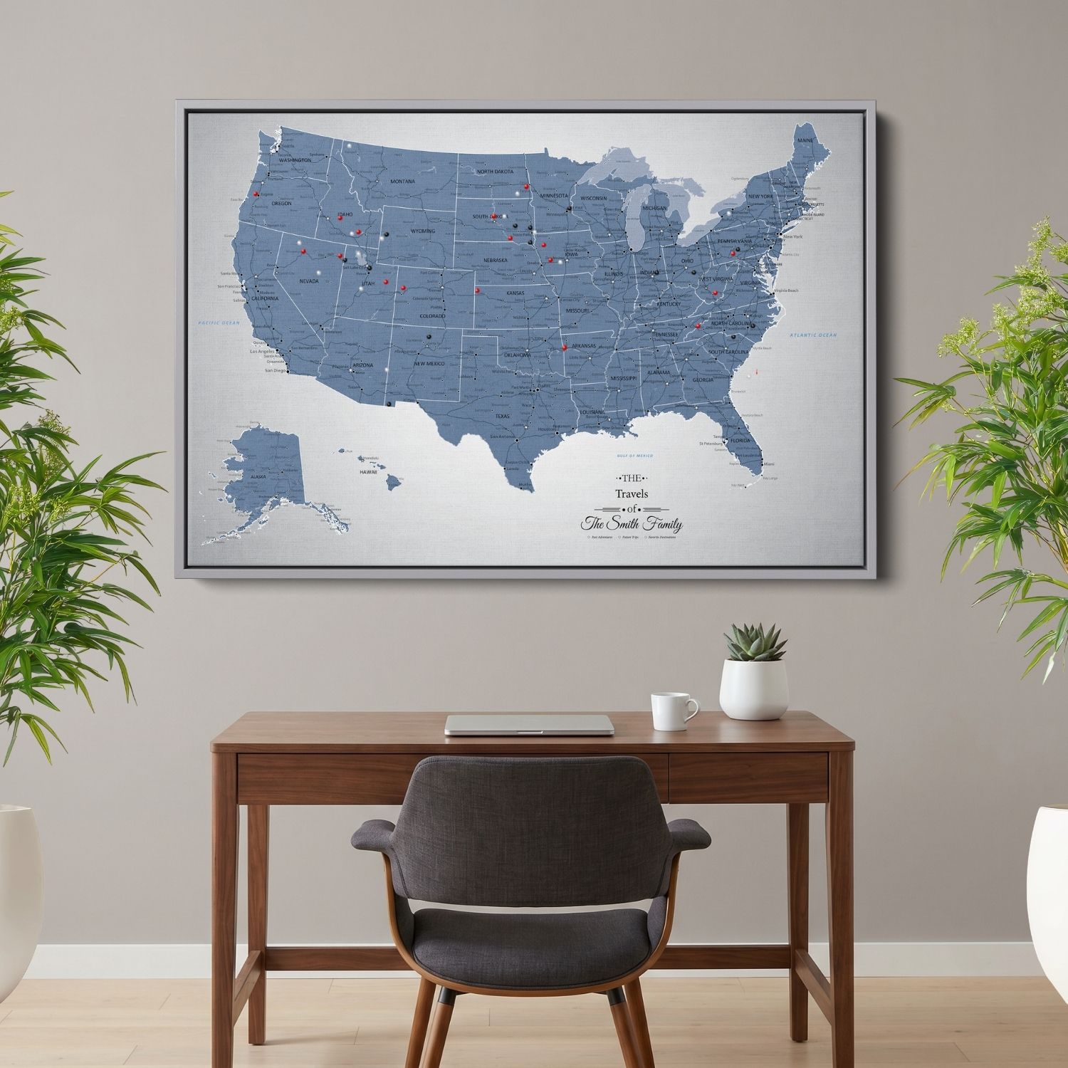 Personalized blue ice USA push pin travel map canvas in silver frame hung above wood desk in home office setting