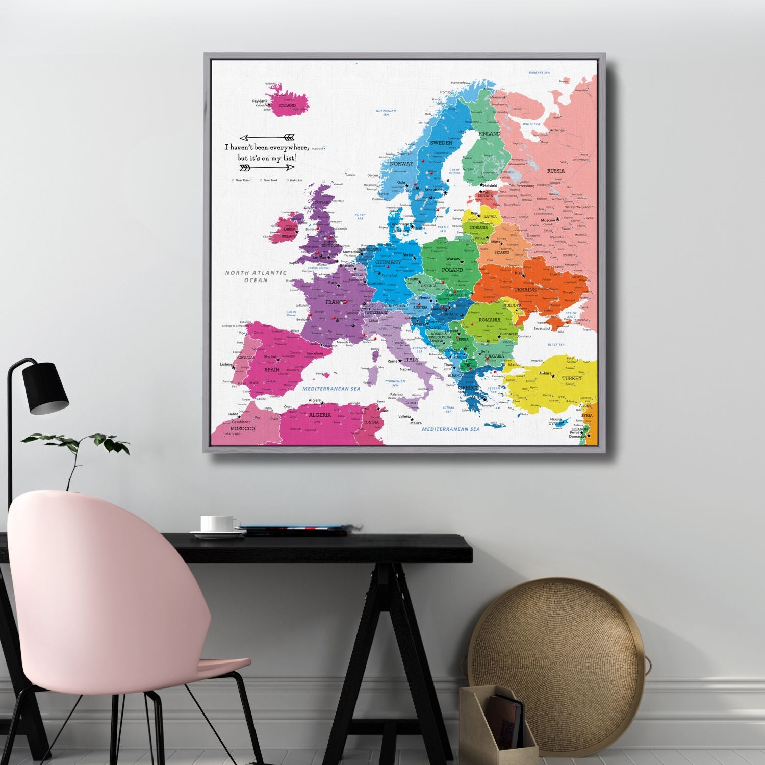 Colorful Europe travel map canvas with pins displayed above modern home office desk