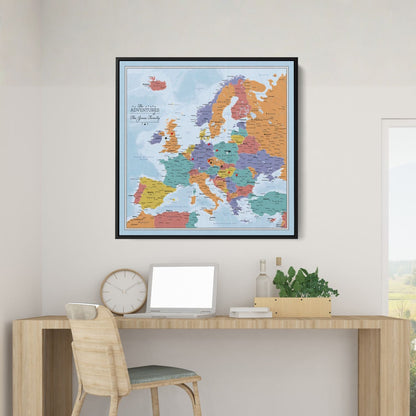 Black framed Blue Oceans Europe travel map with pins displayed above a modern wooden desk