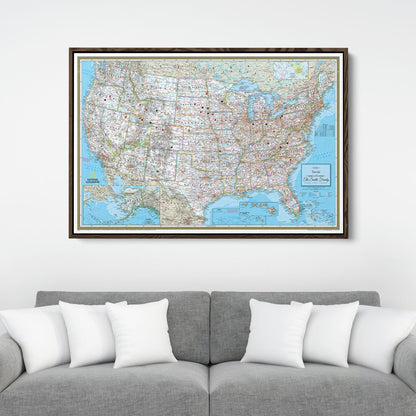Framed Classic USA National Geographic travel pin map canvas hanging above gray sofa with white pillows