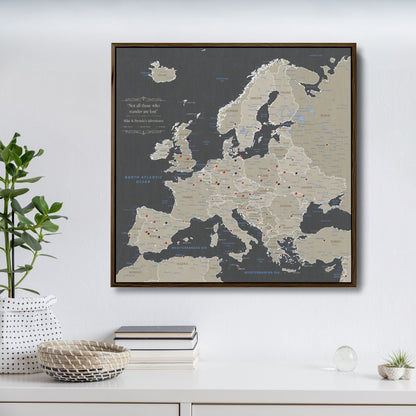 Earth toned Europe travel map canvas with red pins in dark walnut float frame on white wall