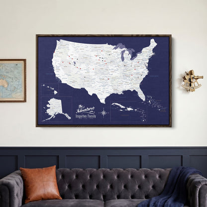 Framed navy canvas USA Caribbean travel map with red and black pins hanging above tufted sofa in living room