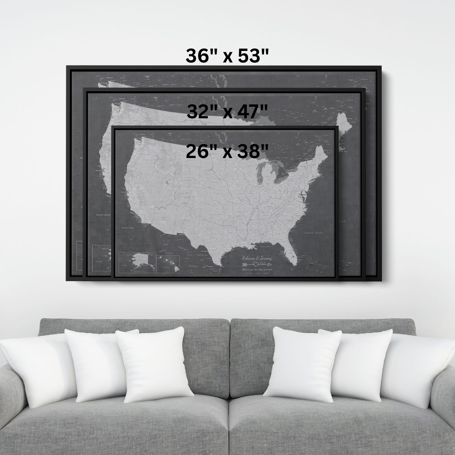Three size options of Stormy Dreams USA canvas travel map with pins displayed above gray sofa