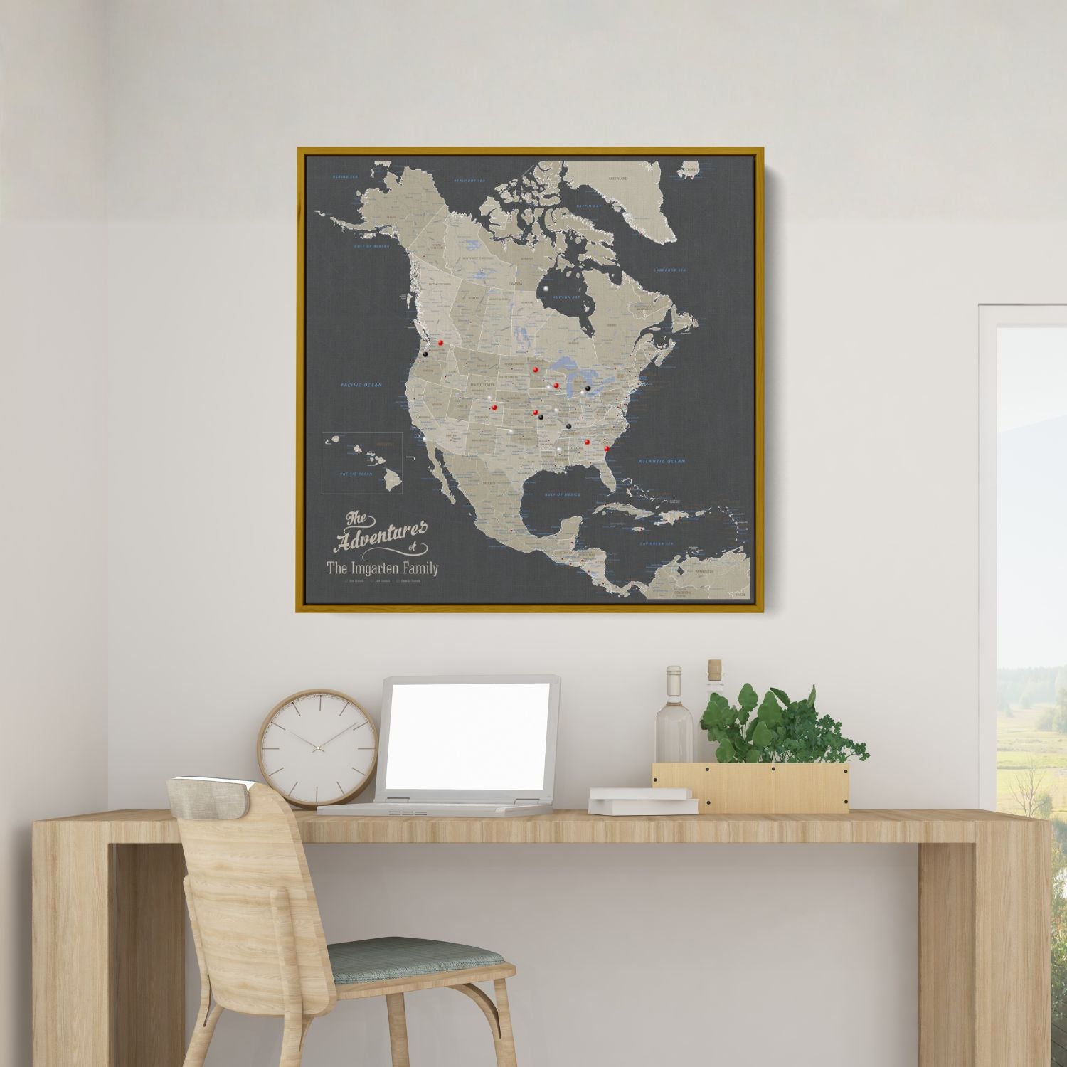 Personalized earth toned North America travel map with push pins in gold frame above modern desk