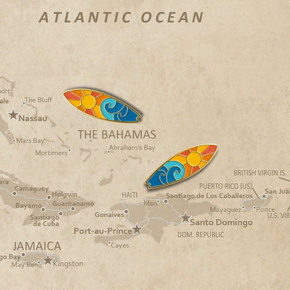 Two surfboard enamel push pins placed on vintage Atlantic Ocean map near Bahamas
