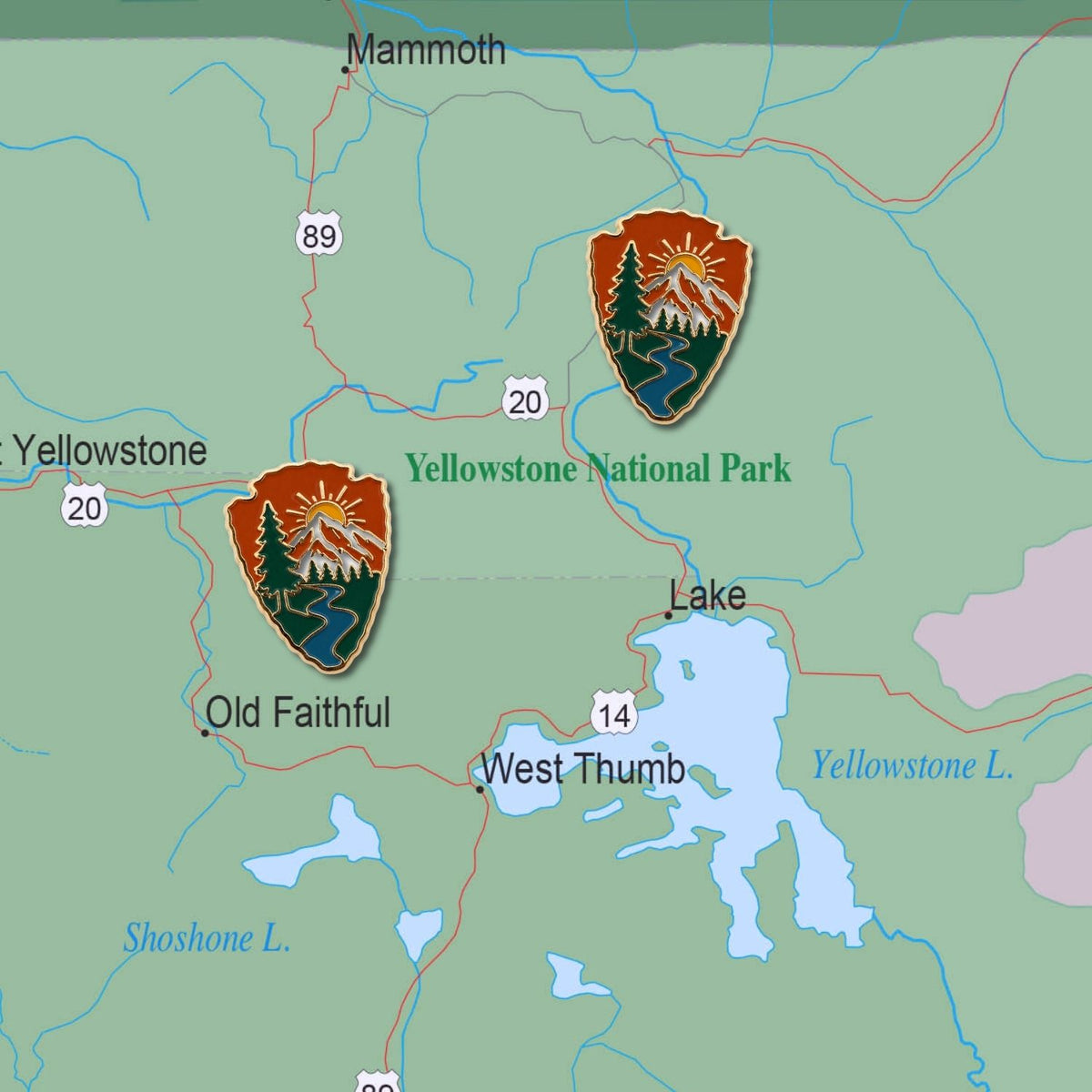 Two arrowhead enamel national park push pins placed on Yellowstone National Park map showing mountain river design