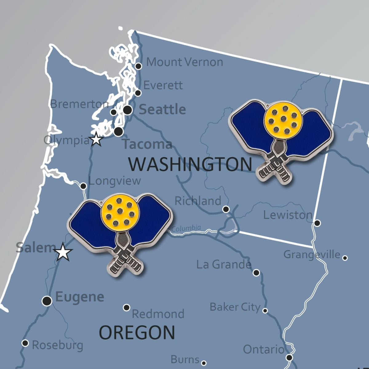 Navy and yellow enamel pickleball paddle push pins placed on Washington Oregon map