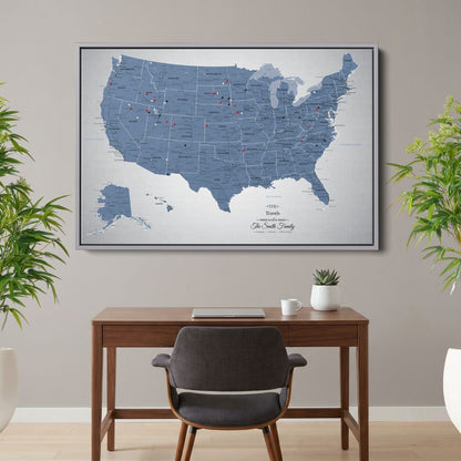 Personalized blue ice USA push pin travel map canvas in silver frame hung above wood desk in home office setting