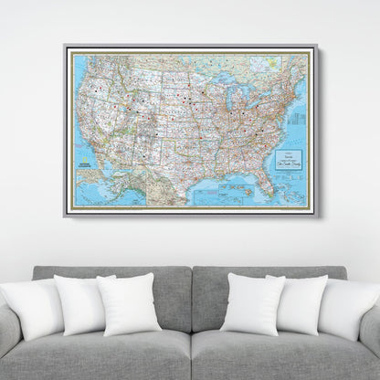 Framed National Geographic Classic USA travel pin map canvas hanging above gray sofa with white pillows