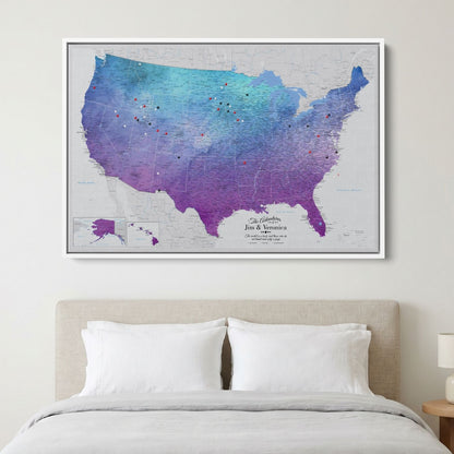 Vibrant violet watercolor USA travel map canvas with pins displayed above bedroom bed