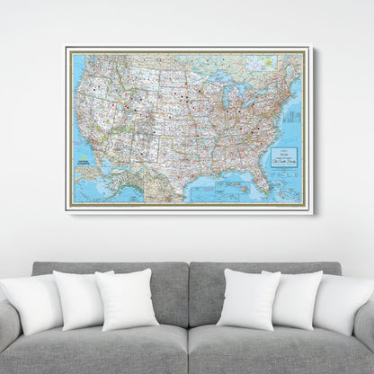 Framed National Geographic Classic USA travel pin map canvas hanging above gray sofa with white pillows
