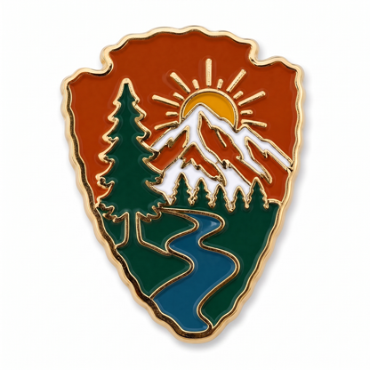 Arrowhead-shaped national park enamel lapel pin with gold trim featuring mountains, pine trees, and winding river